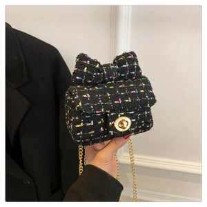 Detail of mini tweed crossbody bag with large bow decoration and gold metal lock