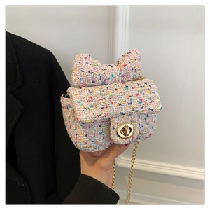 Detail of pink tweed mini crossbody bag with a large bow and golden twist lock