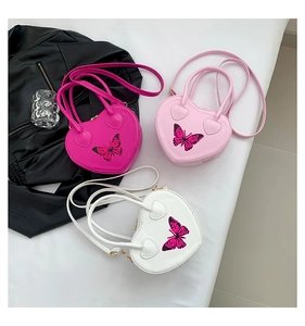 Close-up of heart-shaped bags in rose, pink, and white with butterfly prints