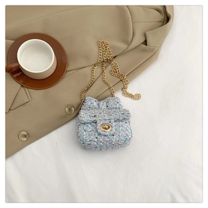Macro shot of blue tweed mini crossbody bag with a bow detail and gold chain strap
