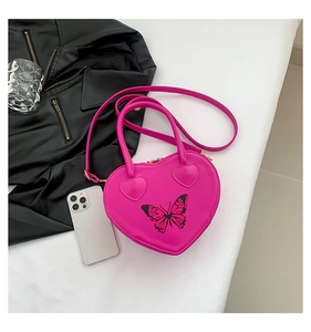 Detail of rose pink heart bag featuring a butterfly print and golden metal zipper