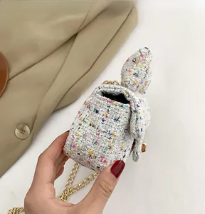 Close-up of colorful tweed texture with gold chain strap on girls' mini crossbody bag