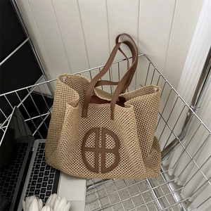 Handwoven straw tote bag with brown leather handles and logo in a shopping cart