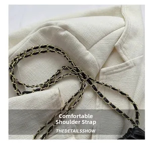 Détail d'un sac seau en cuir avec chaîne dorée et bandoulière tressée en cuir de qualité