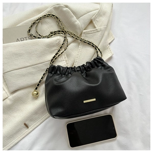 Gros plan du sac nuage plissé noir avec chaîne dorée et texture en cuir grainé lychee