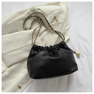Détail du sac nuage plissé noir avec texture lychee et bandoulière chaîne dorée