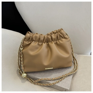 Détail du sac nuage camel avec chaîne dorée et sphère métallique décorative