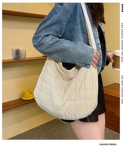 Close-up of white quilted puffer shoulder bag featuring a half-moon hobo design