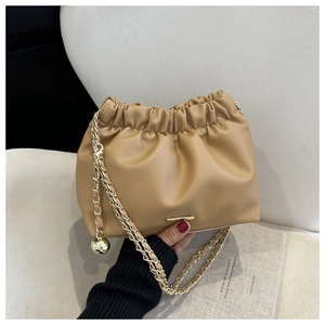 Détail du sac nuage plissé kaki clair avec chaîne dorée et breloque boule en métal