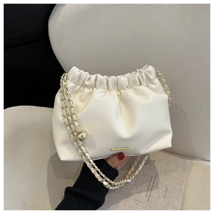Détail du sac nuage plissé crème avec texture cuir grainé et chaîne dorée chic