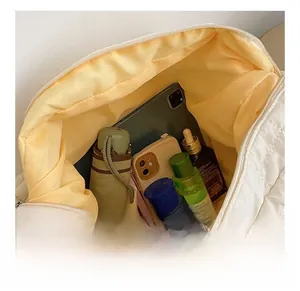 Close-up of quilted white tote bag showing spacious yellow lining and interior storage