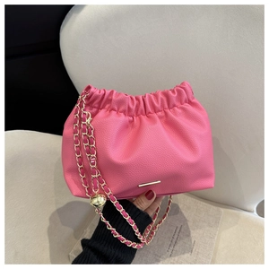 Détail du sac à main plissé rose vif en cuir avec chaîne dorée et finitions métalliques
