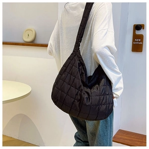 Detailed view of the black quilted texture and puffy stitching on the crossbody hobo bag