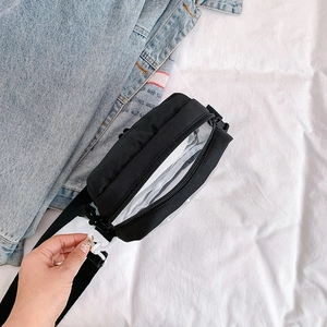 Black nylon and clear PVC crossbody bag with adjustable strap and white buckles