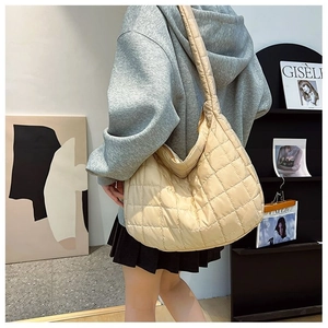 Detail shot of beige quilted nylon hobo bag featuring large capacity and soft texture