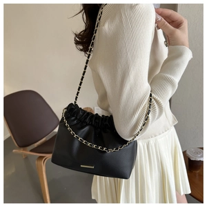 Détail du sac nuage noir plissé avec bandoulière chaîne dorée et cuir grainé élégant
