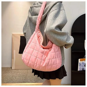 Quilted pink puffer hobo bag worn by model showing large capacity and soft nylon texture