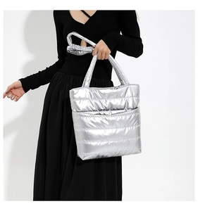 Close-up of metallic silver quilted tote bag with horizontal stitching and soft texture