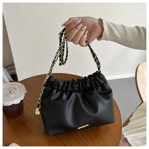 Détail du sac nuage plissé noir avec chaîne dorée et texture cuir grainé litchi