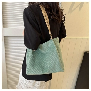Close-up of mint green canvas tote bag with textured weave and leather straps