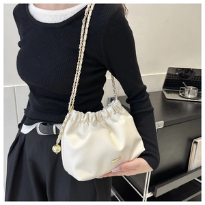 Détail du sac bandoulière plissé blanc avec chaîne dorée et pendentif sphérique