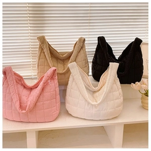 Close-up of quilted down tote bags in pink, beige, black and white on display