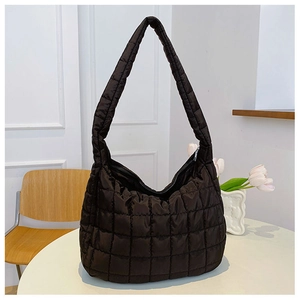 Detail showing the black quilted texture and padded wide strap of the nylon hobo bag