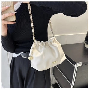 Détail du sac nuage plissé crème avec similicuir texturé et bandoulière chaîne dorée