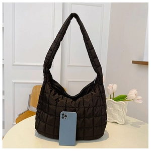 Close-up of black quilted puffer tote bag with glossy finish and size reference