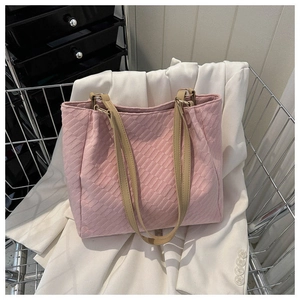 Detail of pink canvas tote bag showing quilted rhombus texture and leather handles
