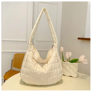 Detail of white quilted puffer shoulder bag featuring classic diamond patterns and soft hobo shape