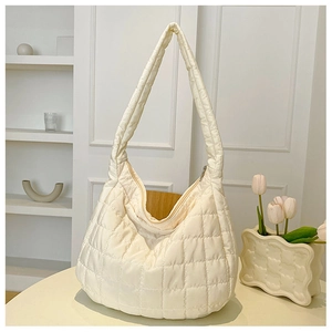 Detail of white quilted hobo bag with plush texture and smooth zipper closure