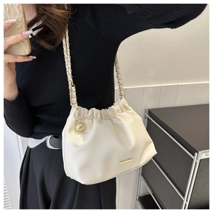Détail du sac blanc plissé avec bandoulière chaîne dorée et pendentif sphérique