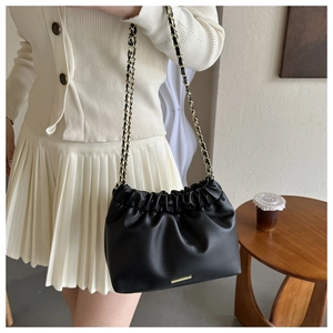 Détail du sac nuage noir plissé en cuir grainé avec bandoulière en chaîne dorée