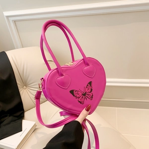 Pink heart-shaped handbag with black butterfly print and adjustable shoulder strap