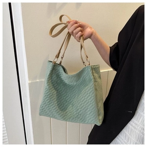 Close-up of mint green canvas tote bag with quilted texture and khaki shoulder straps