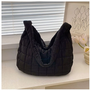 Close-up of black quilted nylon tote bag with square stitching and padded texture detail