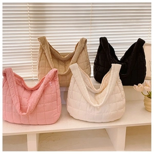 Quilted puffer tote bags in four colors arranged on a minimalist display stand