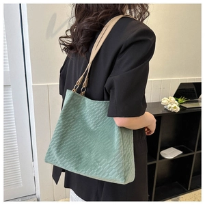 Close-up of mint green canvas tote bag with woven texture and leather handles