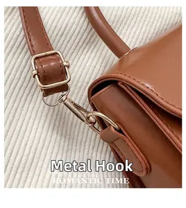 Macro view of golden metal hook hardware and neat stitching on brown leather bag