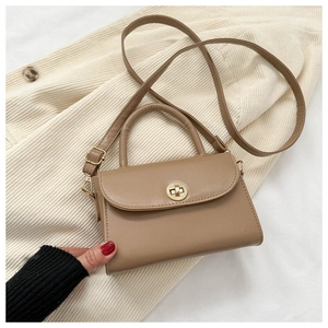 Detail of khaki faux leather handbag featuring a golden circular twist lock closure
