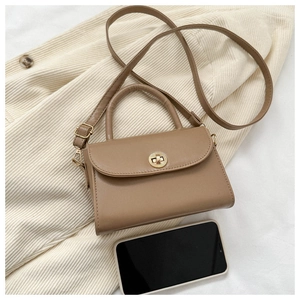 Detail of khaki PU leather bag with round gold metal twist lock and slim shoulder strap