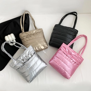 Quilted puffer tote bags in metallic silver, gold, black, and pink with a glossy finish
