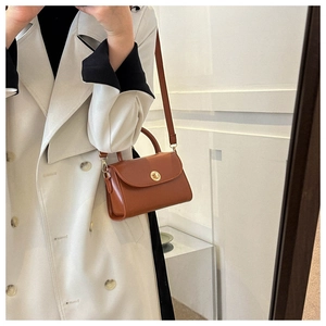Mirror selfie showing the brown vintage crossbody bag paired with a stylish trench coat