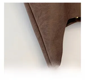 Macro view of dark brown tote bag showing premium lychee grain leather and precise stitching