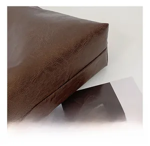 Detailed macro view of dark brown tote bag showing premium lychee grain leather texture