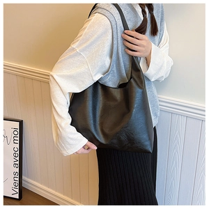Detail of a large black leather Hobo bag worn on the shoulder for a commuter style