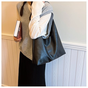 Slouchy black faux leather oversized tote bag shown on model for daily commuting