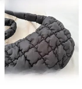 Macro shot of black quilted stitching details and soft puffy fabric texture of the tote bag