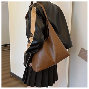 Detail view of large dark brown hobo tote bag in soft leather shown on shoulder